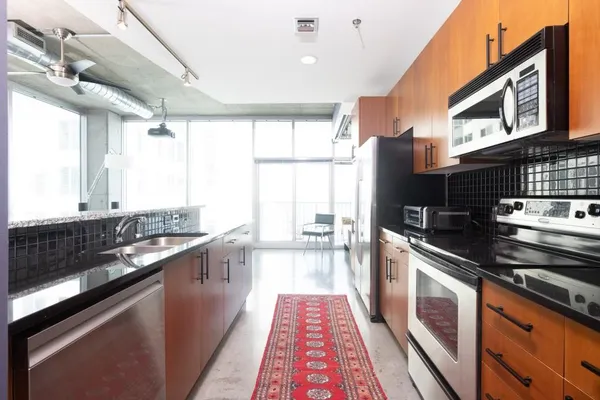 a large kitchen with stainless steel appliances granite countertop a stove and a sink