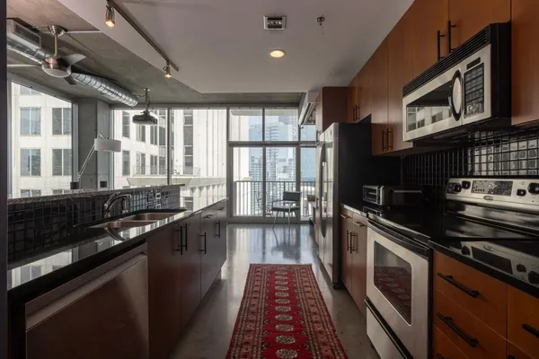 a large kitchen with stainless steel appliances granite countertop a stove and a sink