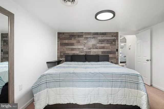 a bedroom with a bed and a wall painting