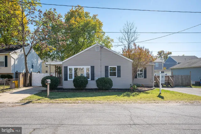 a view of a house with a yard and a large tree