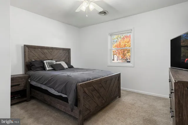 a bedroom with a bed and a painting on the wall