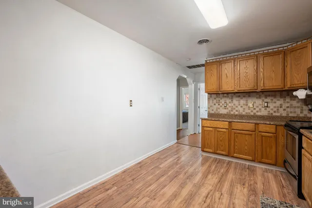 a kitchen with granite countertop a sink cabinets and wooden floor