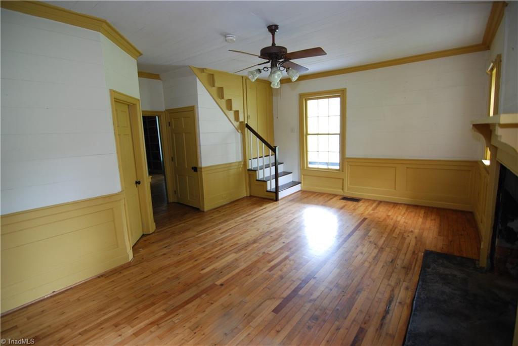 1036 Covington House Road Walnut Cove, NC 27052 - Photo 14 of 29 Dining room - Notice the beautiful hardwood floors. To the left is a full bathroom. Entry into the living room. Small closet under stairs. These stairs are one of 2 sets of stairs that lead to the 2nd floor. The other set of stairs are located at the rear of the home.