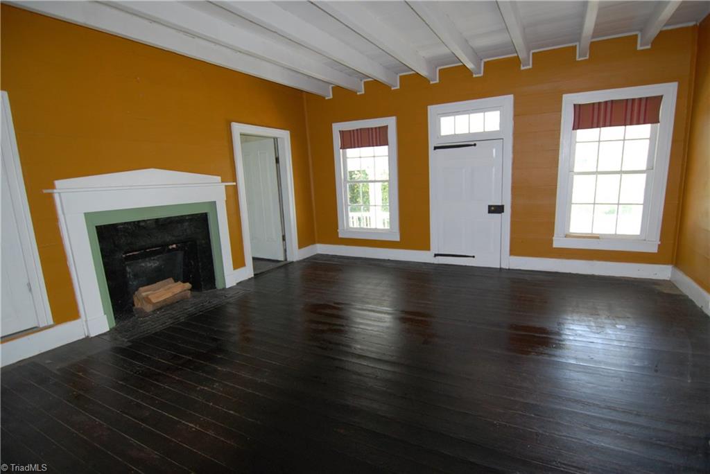 1036 Covington House Road Walnut Cove, NC 27052 - Photo 23 of 29 Middle upstairs bedroom. Door to the far left leads to a bathroom. Door beside fireplace leads to another bedroom. Large door between windows leads to the front upstairs porch.