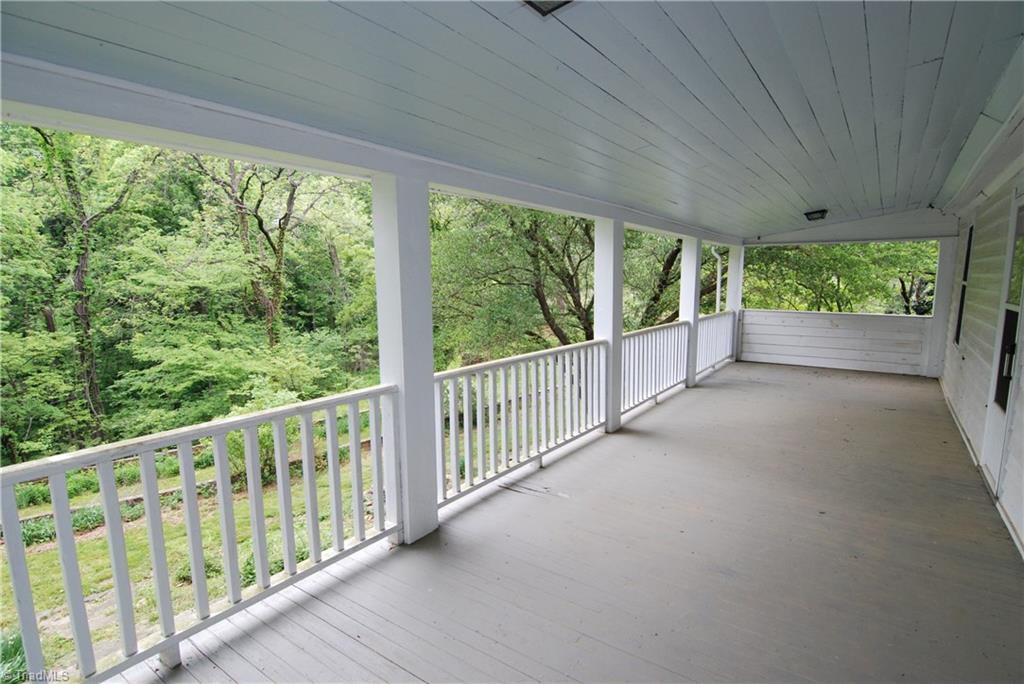 1036 Covington House Road Walnut Cove, NC 27052 - Photo 26 of 29 Outside upper rear porch that overlooks the rear back yard. Enjoy your mornings on this beautiful porch. A splendid view of the mature trees, beautiful yard and stone work.