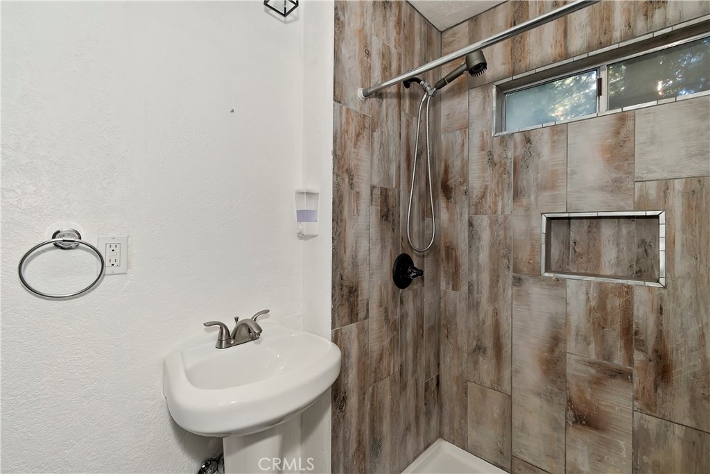 26331 Alpine Lane Twin Peaks, CA 92391 - Photo 14 of 41 a bathroom with a sink a mirror and a shower