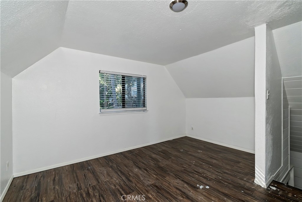 26331 Alpine Lane Twin Peaks, CA 92391 - Photo 24 of 41 an empty room with wooden floor and windows