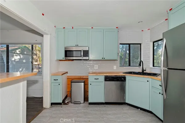 a kitchen with stainless steel appliances granite countertop a refrigerator and a stove top oven
