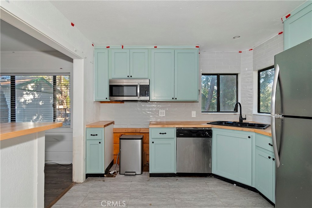 26331 Alpine Lane Twin Peaks, CA 92391 - Photo 5 of 41 a kitchen with stainless steel appliances granite countertop a refrigerator and a stove top oven