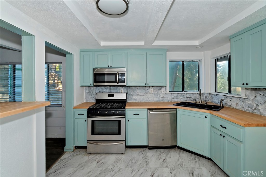 26331 Alpine Lane Twin Peaks, CA 92391 - Photo 7 of 41 a kitchen with a sink stove and microwave