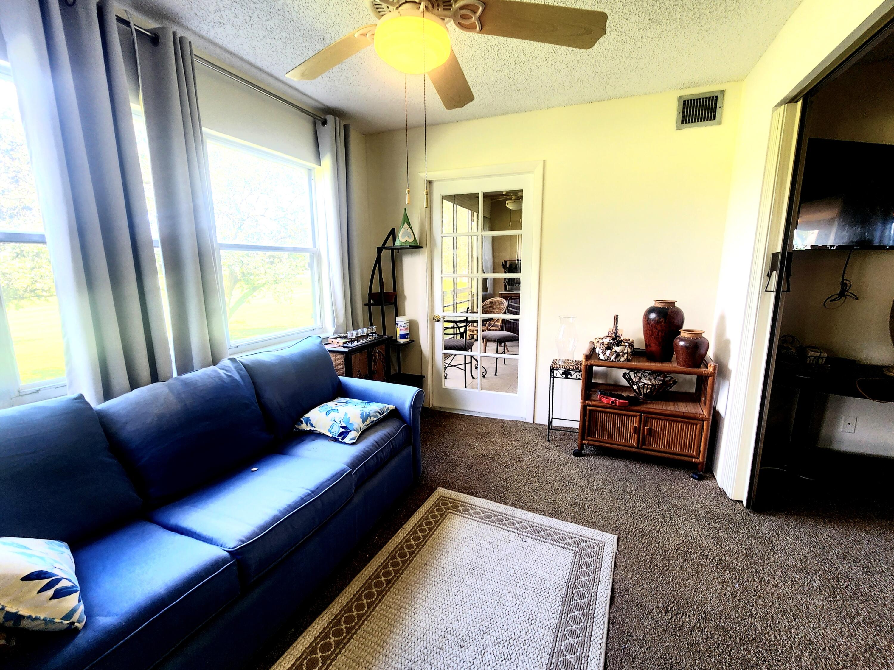 3959 Via Poinciana, Unit 208 Lake Worth, FL 33467 - Photo 11 of 32 a living room with furniture and a flat screen tv