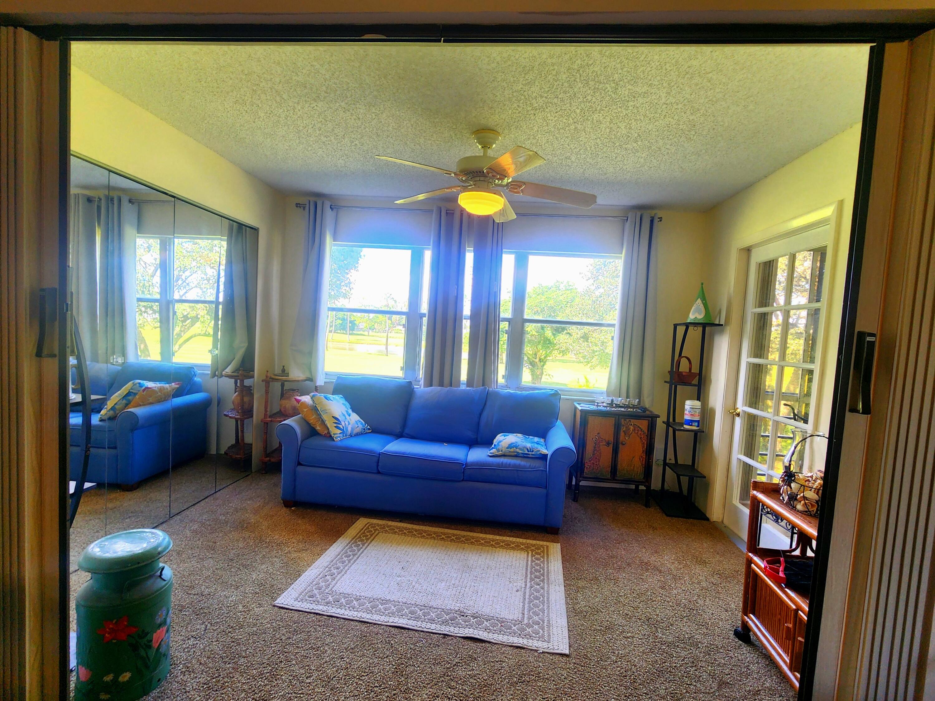 3959 Via Poinciana, Unit 208 Lake Worth, FL 33467 - Photo 14 of 32 a living room with furniture and a window