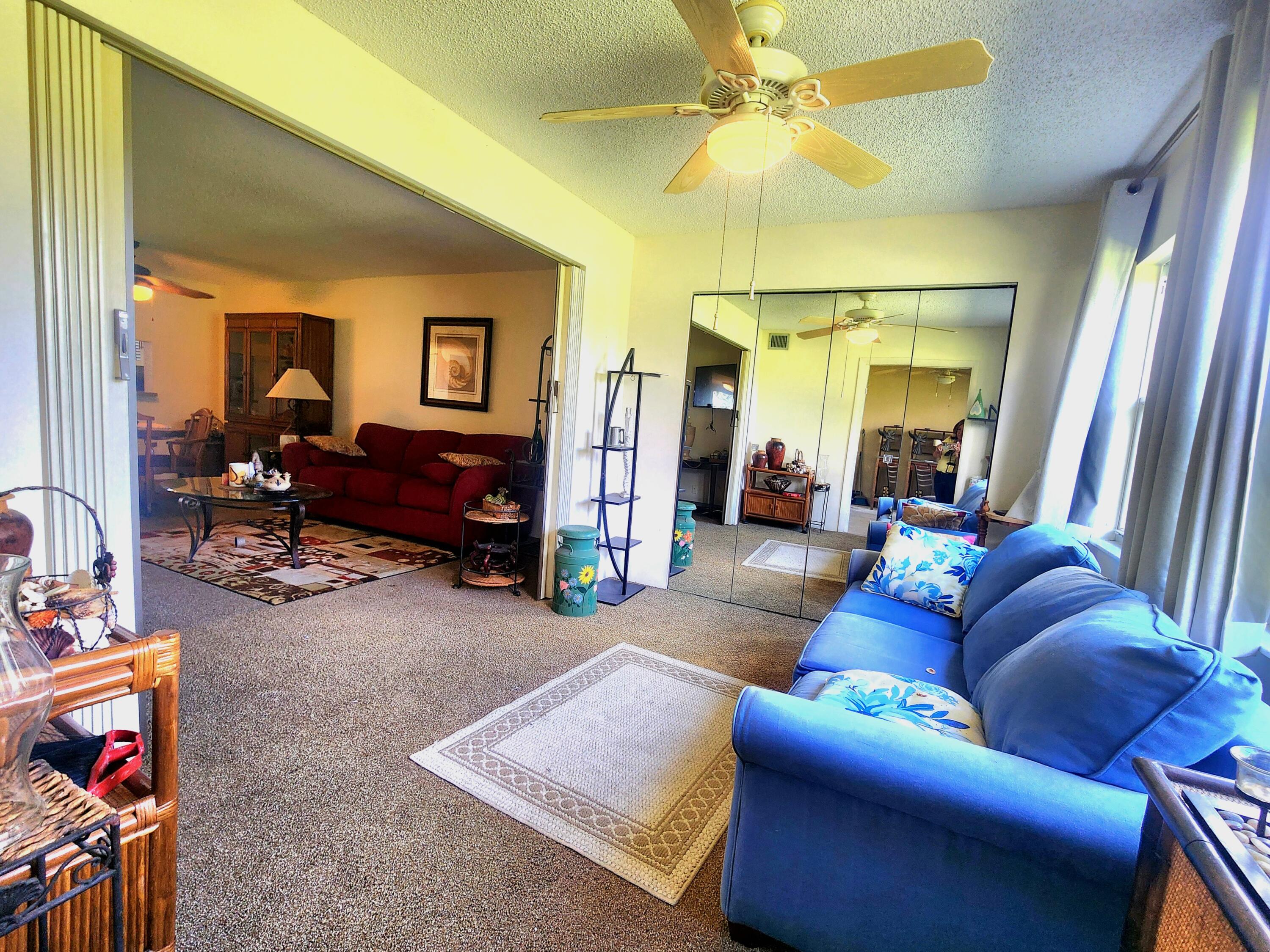 3959 Via Poinciana, Unit 208 Lake Worth, FL 33467 - Photo 15 of 32 a living room with furniture and a flat screen tv