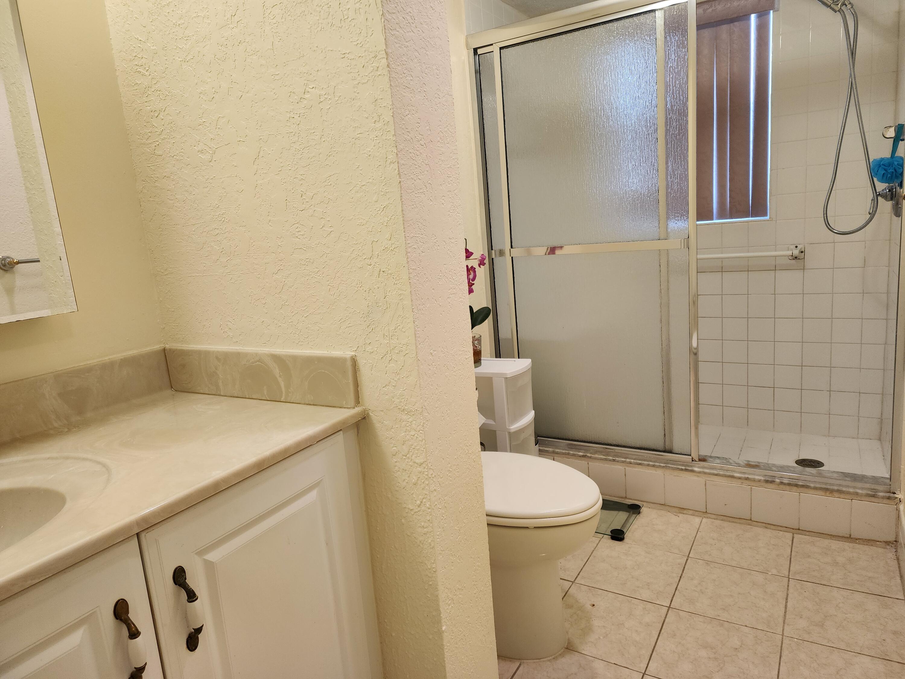 3959 Via Poinciana, Unit 208 Lake Worth, FL 33467 - Photo 21 of 32 a bathroom with a sink a toilet and shower
