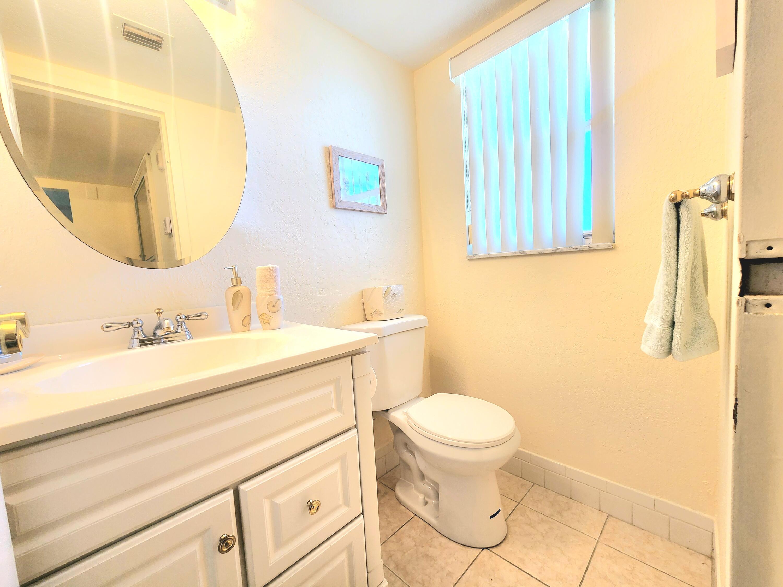 3959 Via Poinciana, Unit 208 Lake Worth, FL 33467 - Photo 22 of 32 a bathroom with a sink and a mirror