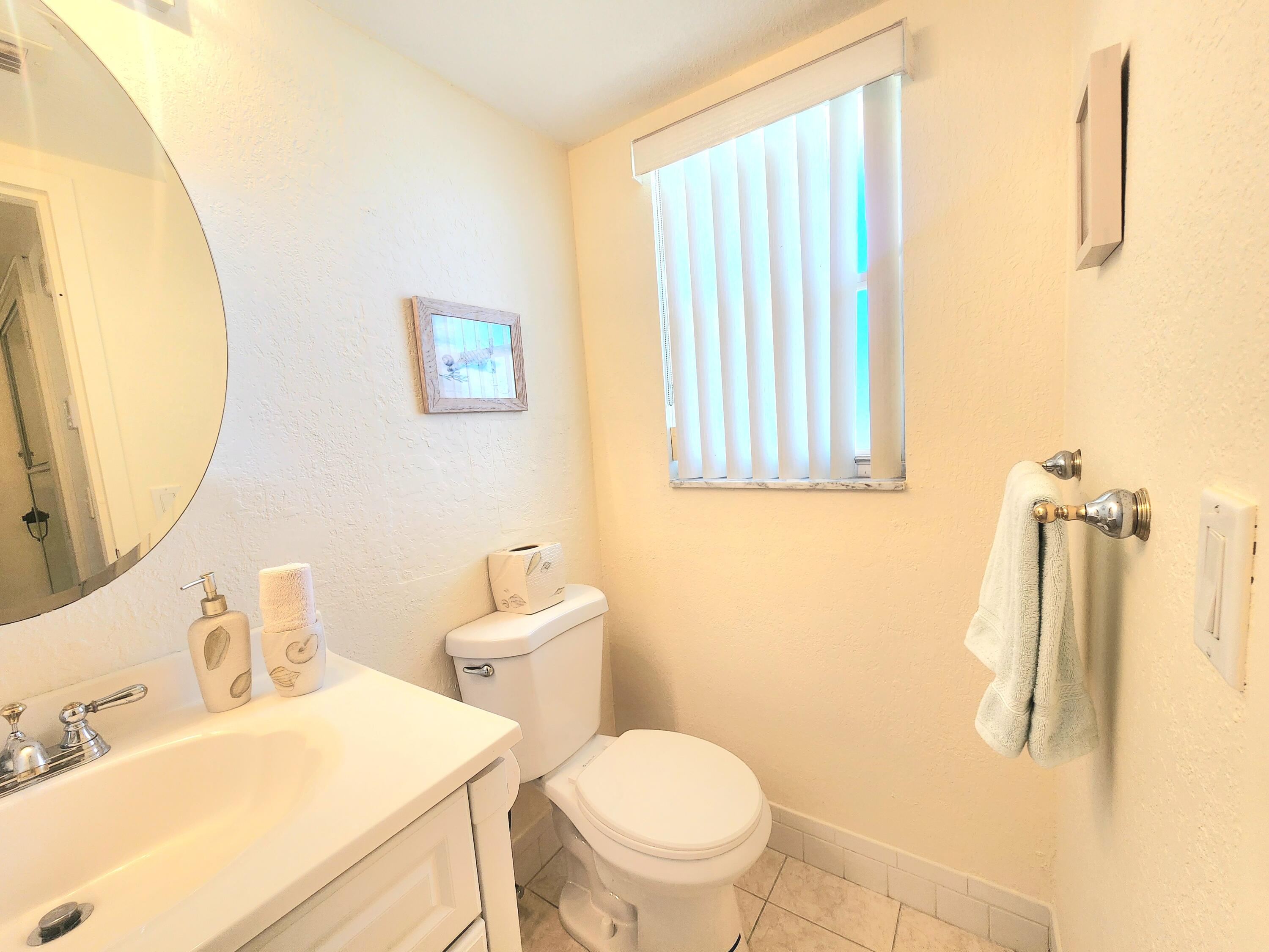 3959 Via Poinciana, Unit 208 Lake Worth, FL 33467 - Photo 23 of 32 a white toilet sitting next to a bathroom sink
