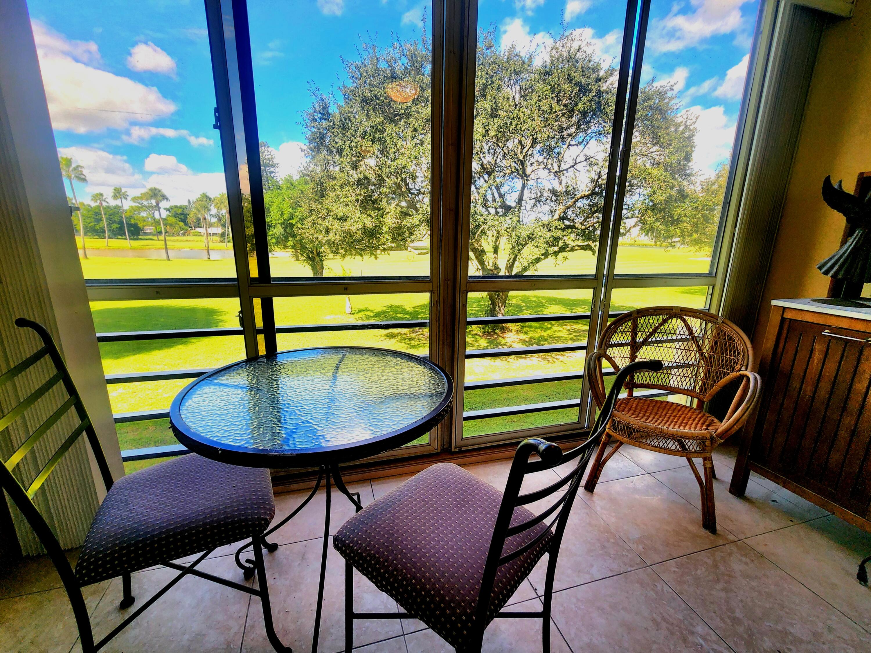 3959 Via Poinciana, Unit 208 Lake Worth, FL 33467 - Photo 3 of 32 a view of a chairs and table in patio