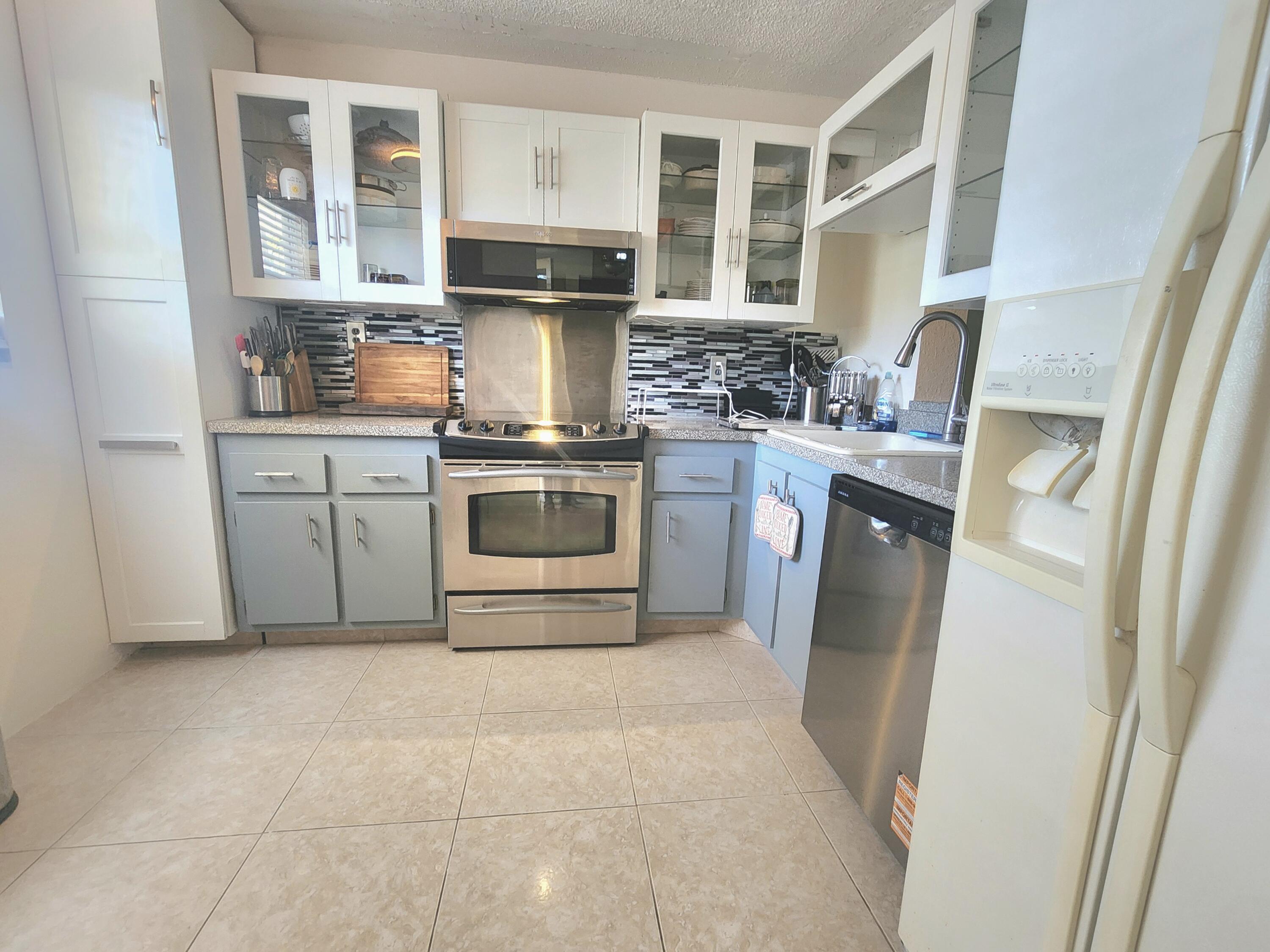 3959 Via Poinciana, Unit 208 Lake Worth, FL 33467 - Photo 6 of 32 a kitchen with a stove top oven and sink