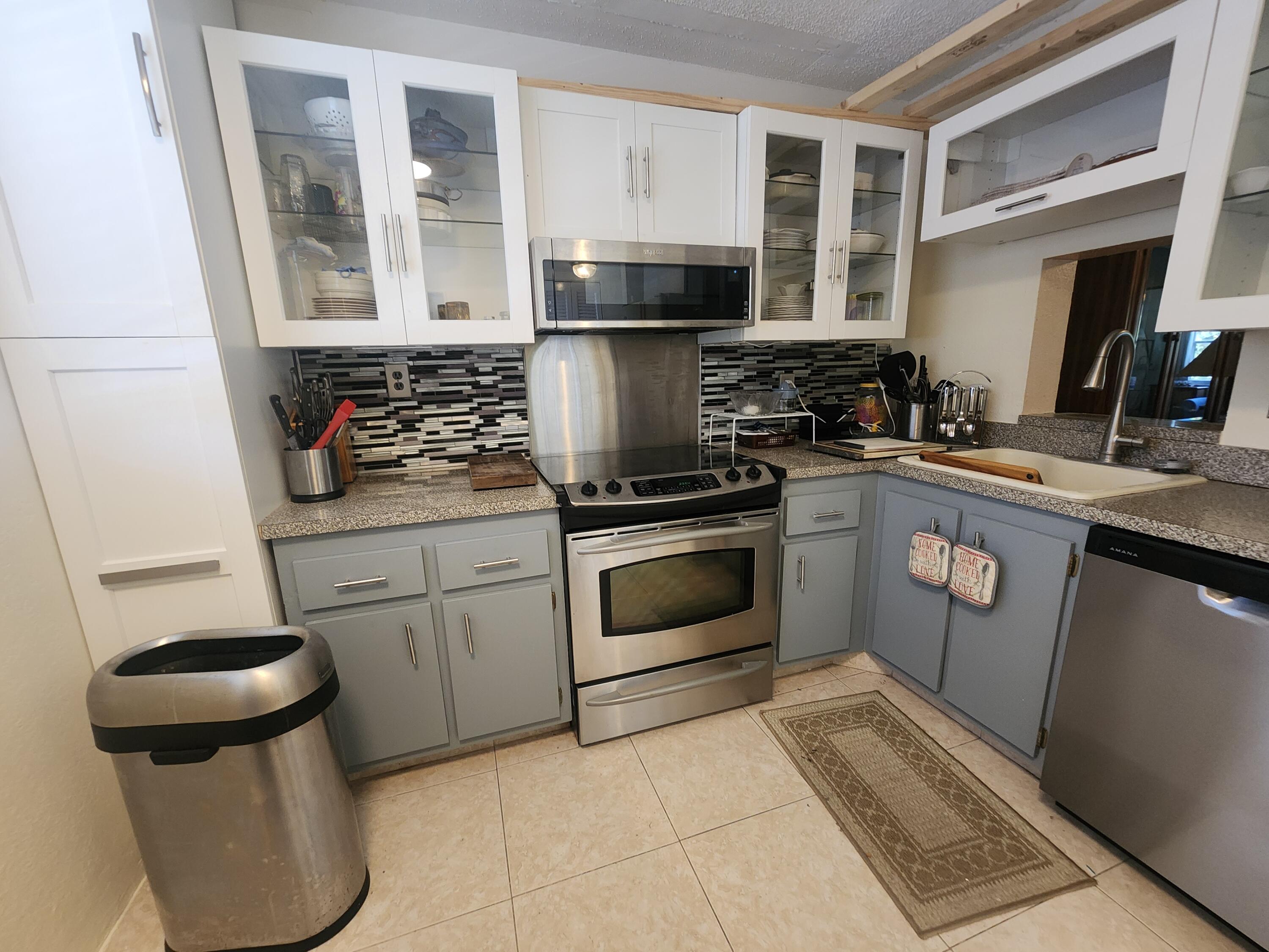 3959 Via Poinciana, Unit 208 Lake Worth, FL 33467 - Photo 7 of 32 a kitchen with a stove and a sink