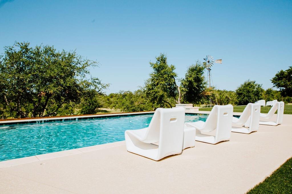 2300 West Fitzhugh Road Dripping Springs, TX 78620 - Photo 7 of 39 a white bench sitting in the middle of a garden