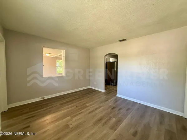 a kitchen with stainless steel appliances granite countertop a refrigerator a sink and white cabinets
