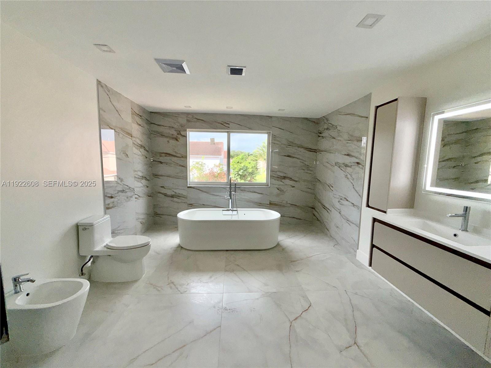 15254 Southwest 109th Street Miami, FL 33196 - Photo 21 of 48 a bathroom with a granite countertop sink a toilet a mirror and bathtub