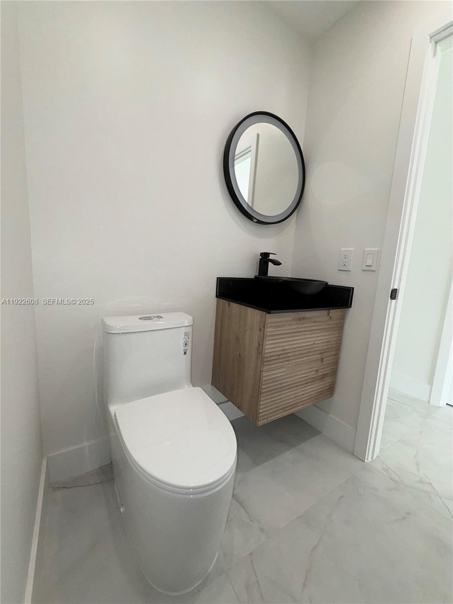15254 Southwest 109th Street Miami, FL 33196 - Photo 43 of 48 a bathroom with a toilet a sink and a mirror