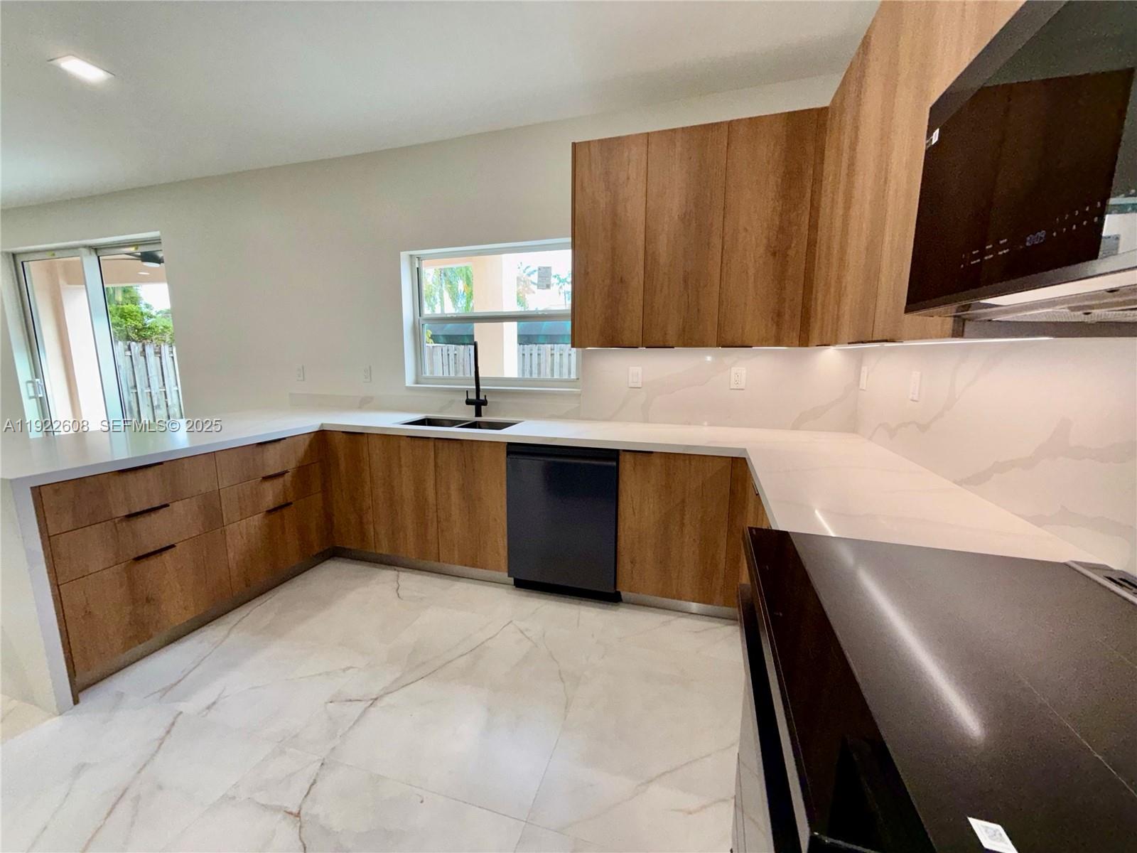 15254 Southwest 109th Street Miami, FL 33196 - Photo 9 of 48 a kitchen with stainless steel appliances granite countertop a sink a stove a microwave a counter top and cabinets