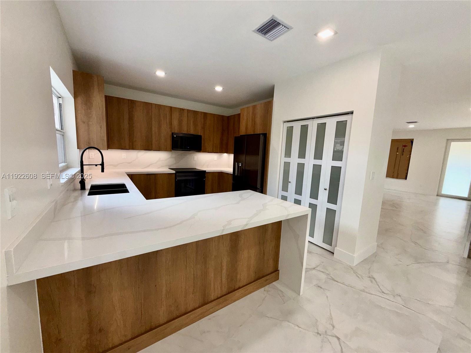 15254 Southwest 109th Street Miami, FL 33196 - Photo 10 of 48 a large white kitchen with sink and washing machine