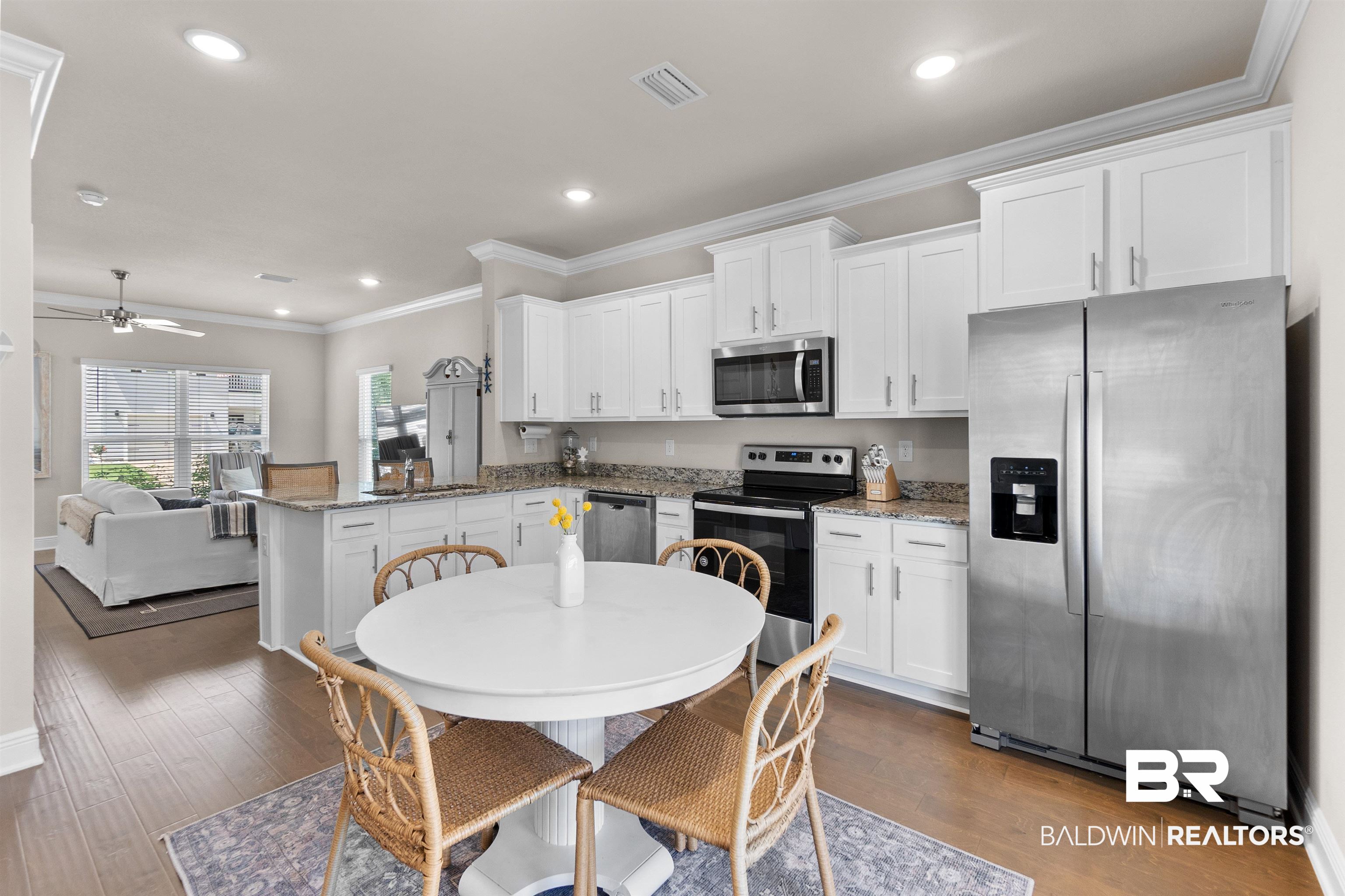 23975 Cottage Loop Orange Beach, AL 36561 - Photo 5 of 23 Kitchen featuring ceiling fan, crown molding, stainless steel appliances, wood-type flooring, and a center island