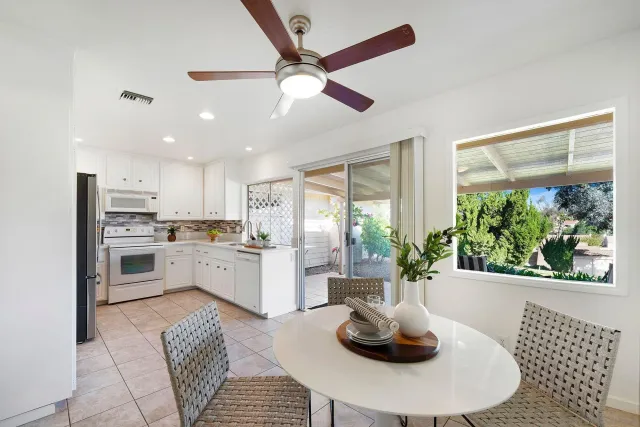 a kitchen with furniture a refrigerator and a chandelier