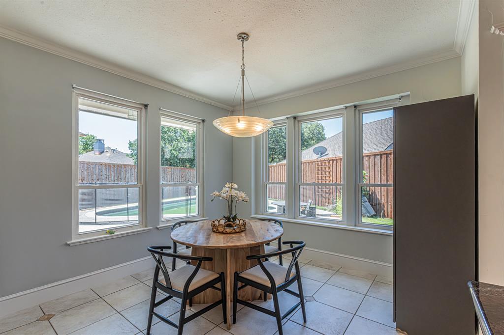 300 Sundance Circle Irving, TX 75063 - Photo 23 of 39 Dining area featuring large windows, crown molding, a built-in cabinetry, and tile flooring