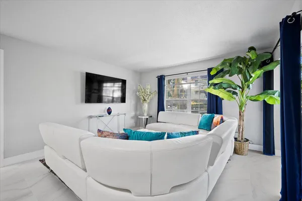a living room with furniture and a potted plant