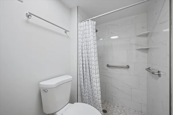 a bathroom with a shower a toilet and a shower