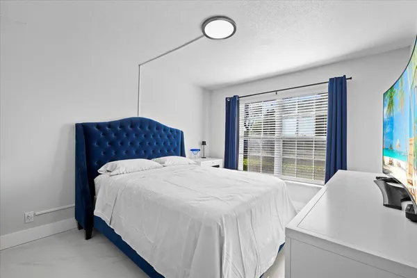 a bedroom with a bed and a large window