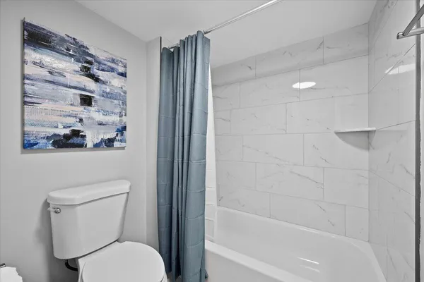 a white toilet sitting next to a bathtub