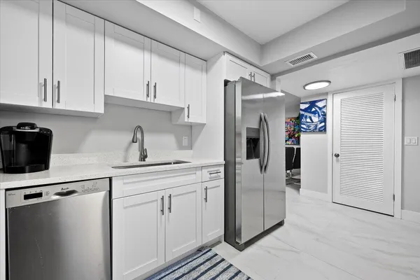 a kitchen with stainless steel appliances a refrigerator sink and cabinets