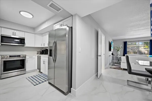 a kitchen with stainless steel appliances granite countertop a refrigerator and a stove top oven