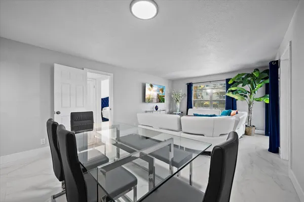 a view of a dining room with furniture and a potted plant