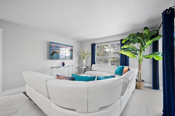 a living room with furniture and a potted plant