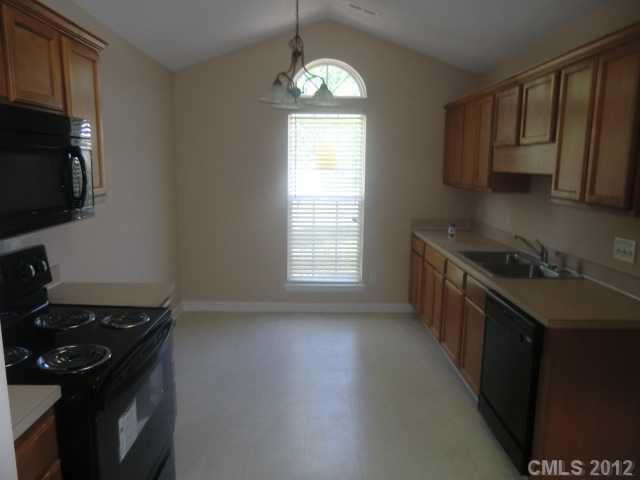 9033 Foggy Meadow Road Charlotte, NC 28269 - Photo 4 of 9 a kitchen with granite countertop a stove and a sink