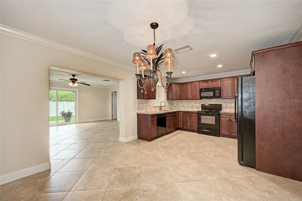 1330 Georgetowne Circle Sarasota, FL 34232 - Photo 10 of 46 a kitchen with stainless steel appliances kitchen island granite countertop a refrigerator and a sink