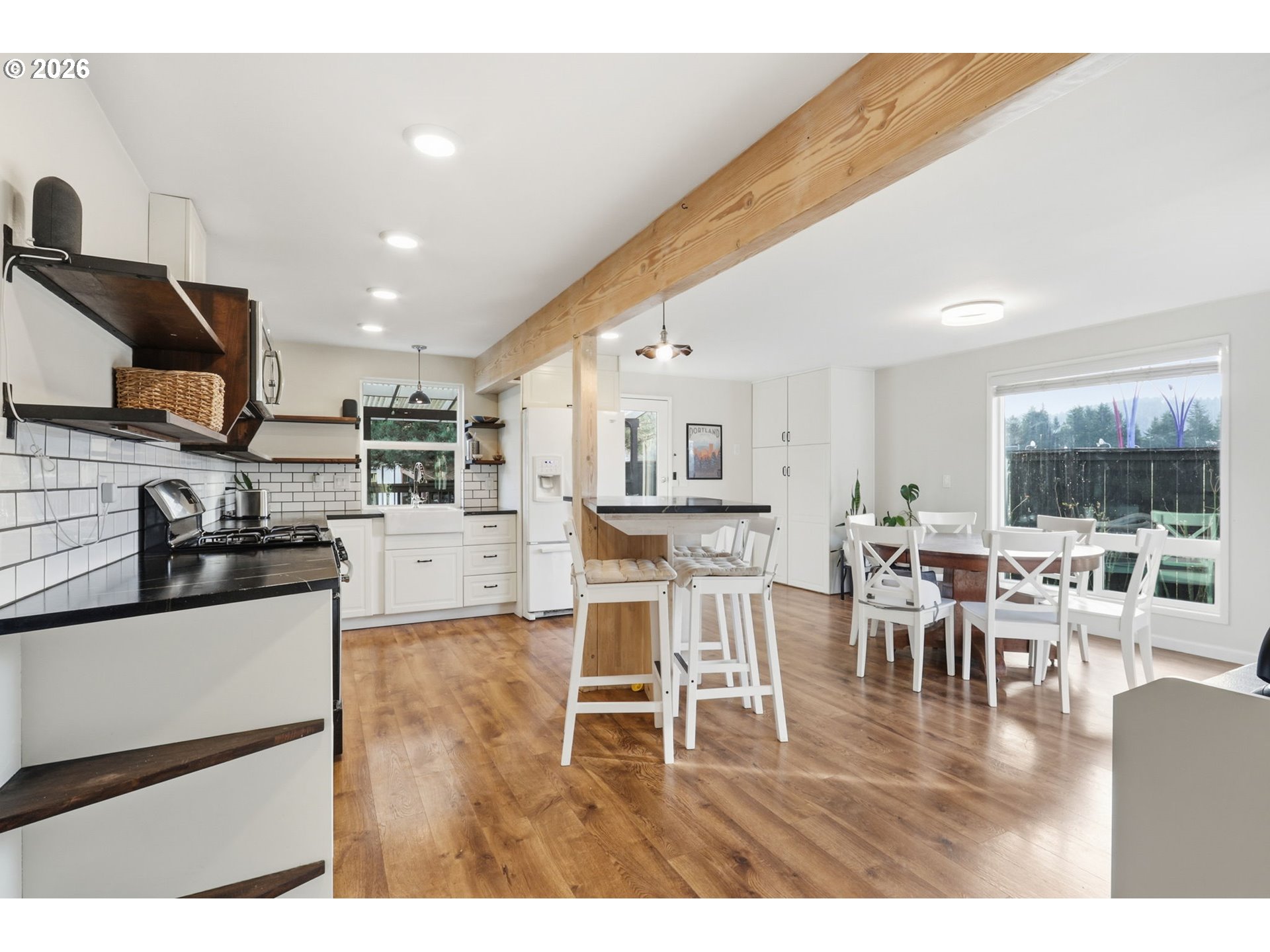 19350 Southwest Murphy Street Beaverton, OR 97078 - Photo 4 of 45 a kitchen with stainless steel appliances granite countertop a stove top oven a sink a dining table and chairs with wooden floor