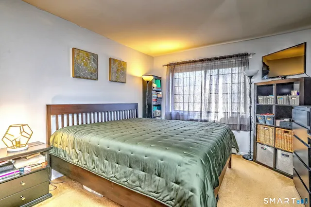 a bed sitting in a bedroom next to a window