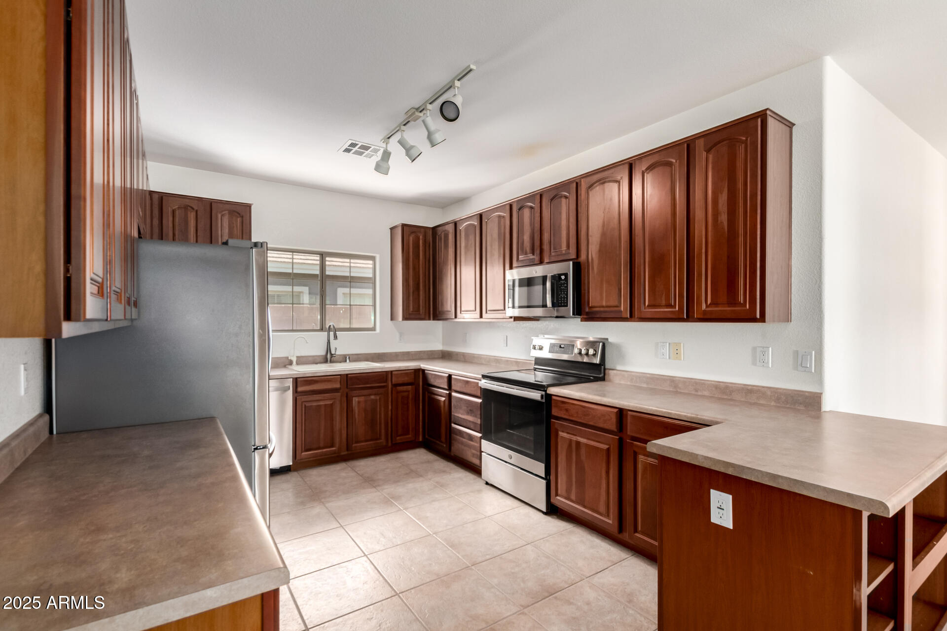 2602 South Nielson Street Gilbert, AZ 85295 - Photo 11 of 39 a kitchen with stainless steel appliances granite countertop wooden cabinets a stove top oven a sink and dishwasher