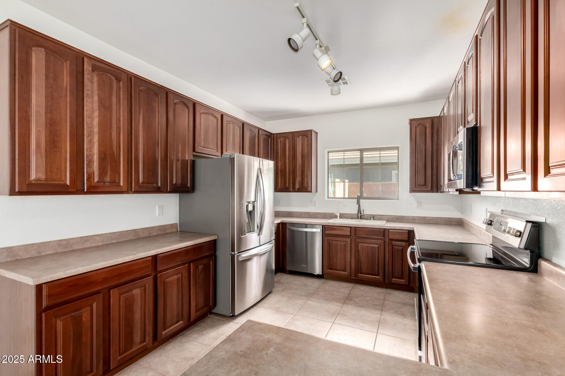 2602 South Nielson Street Gilbert, AZ 85295 - Photo 12 of 39 a kitchen with stainless steel appliances granite countertop a refrigerator a sink dishwasher a stove a dining table and chairs with wooden floor
