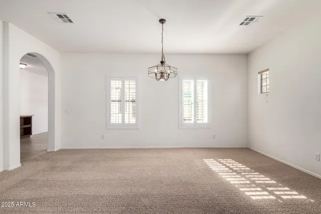 a view of an empty room with window and cabinet