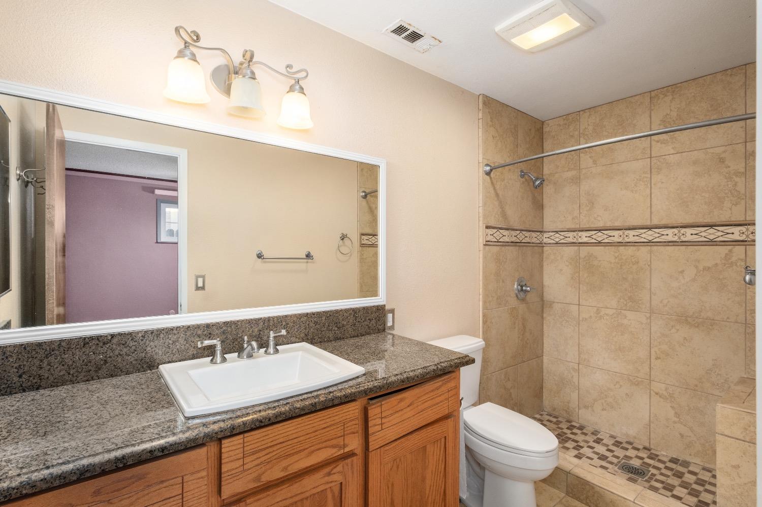 915 Fordham Avenue Clovis, CA 93611 - Photo 16 of 23 a bathroom with a granite countertop sink toilet and shower