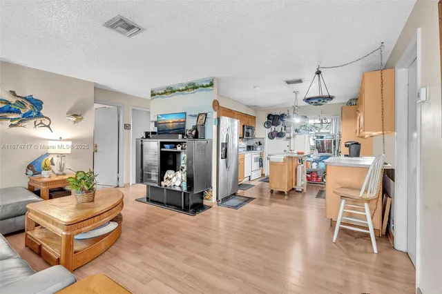 a kitchen with stainless steel appliances granite countertop a refrigerator a oven a stove and a sink