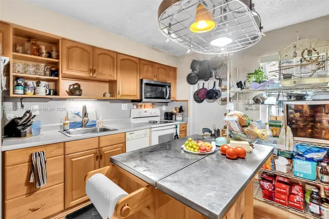 a kitchen with stainless steel appliances granite countertop a sink a stove and a wooden floors